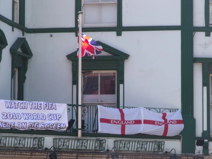 people holding large banners near a flag and window