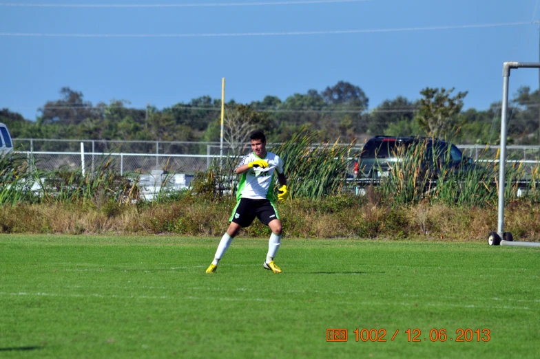 young man on soccer field holding yellow and white ball