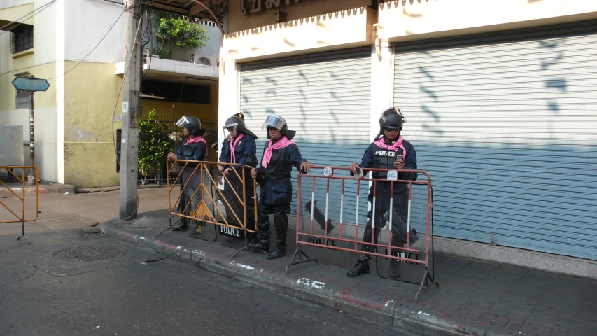 two groups of police officers stand at a closed gate