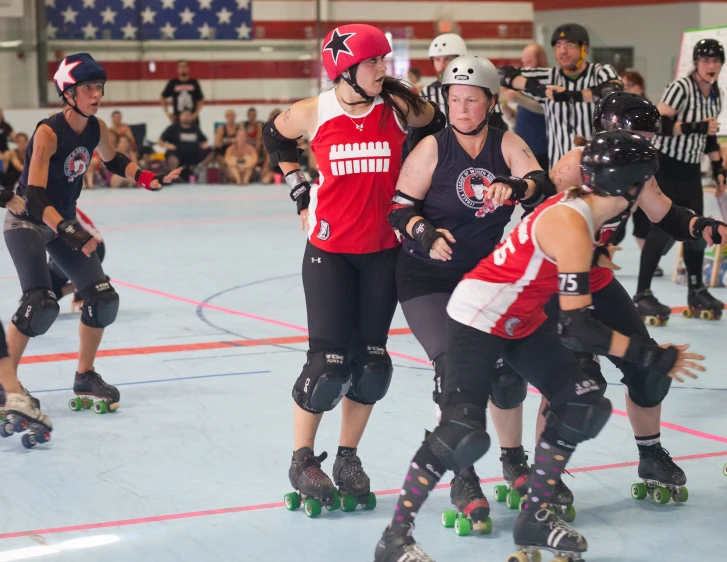 several women roller blades in a competition on an indoor court