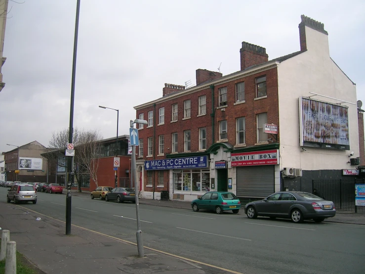 a city street with cars, store fronts and businesses