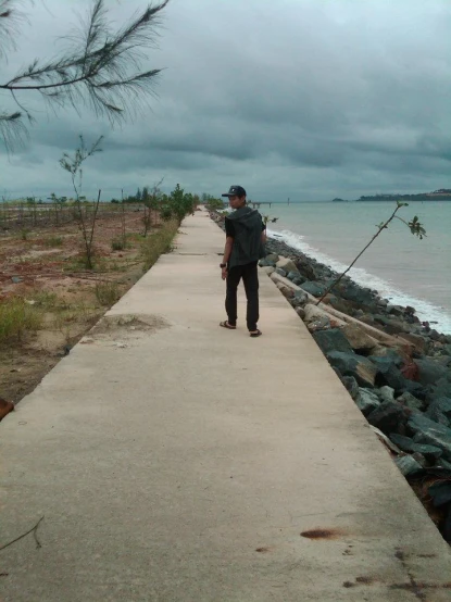a man is walking on a path overlooking the ocean