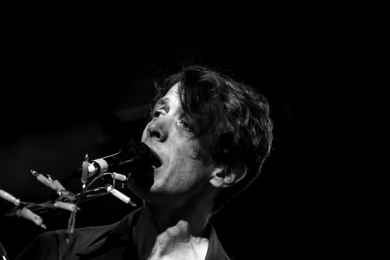 black and white pograph of musician singing into microphone