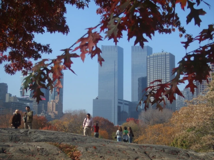 people walking on a trail above a city