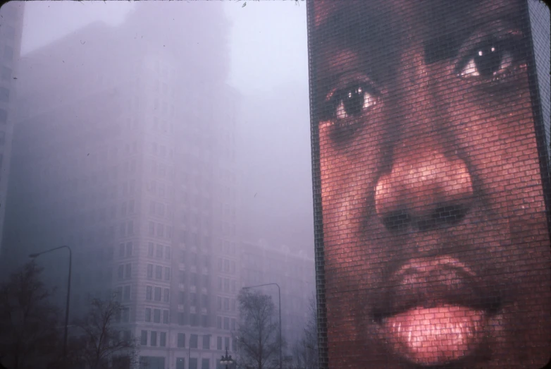 large building on foggy day, in background a man's face and the city