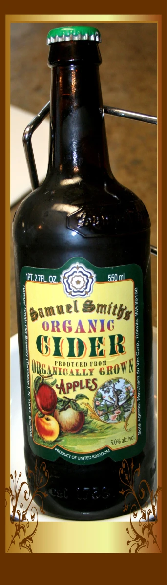 a glass jug of organic cider sits on a tray