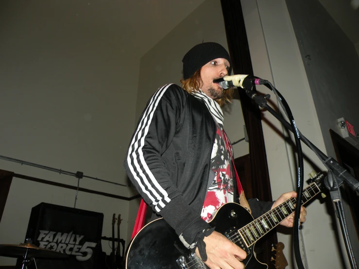 a young man with long hair plays the guitar