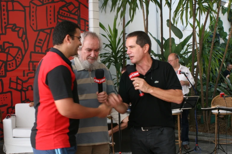 two men standing in a lobby, having a conversation