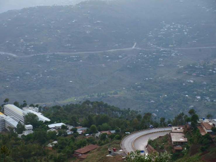 a view of city in the rain and hills