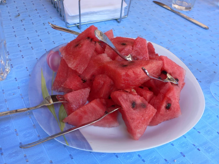 a close up of a plate of fruit with spoons