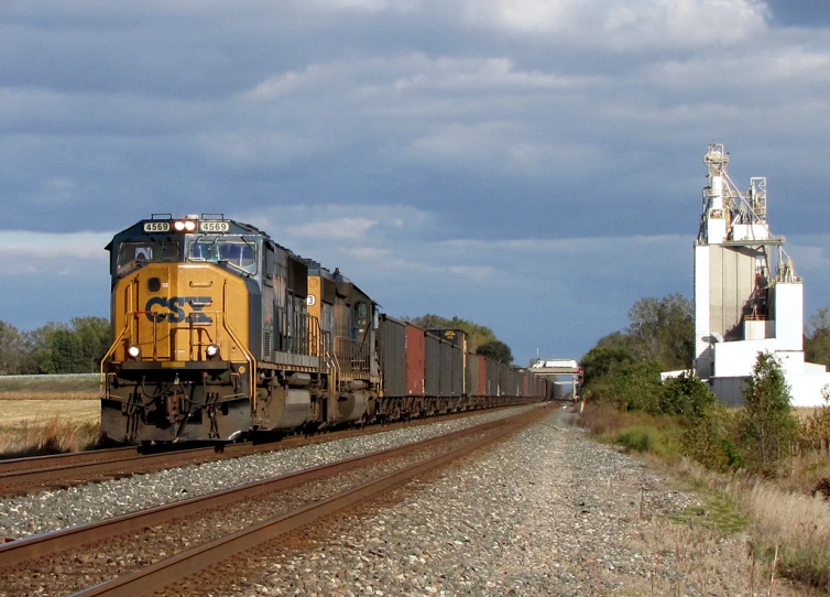 the train is passing in front of some silo