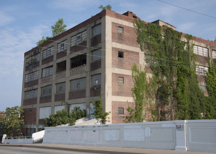 an old brick building is near a fence