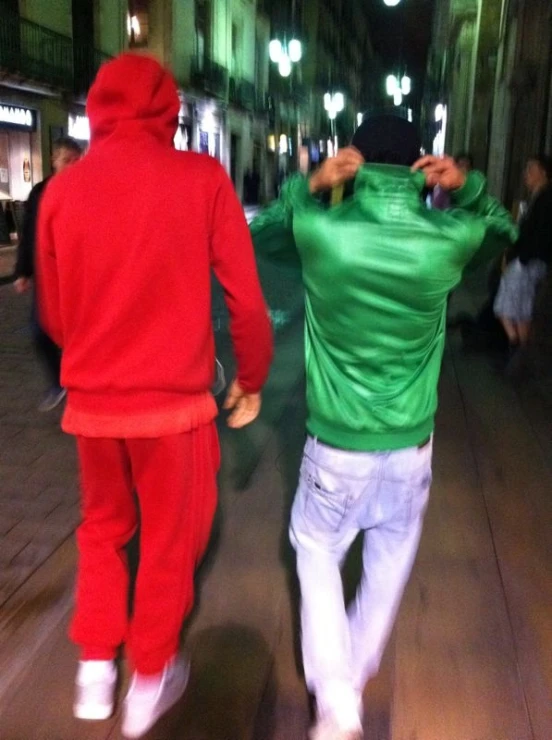 two people walking down a street at night