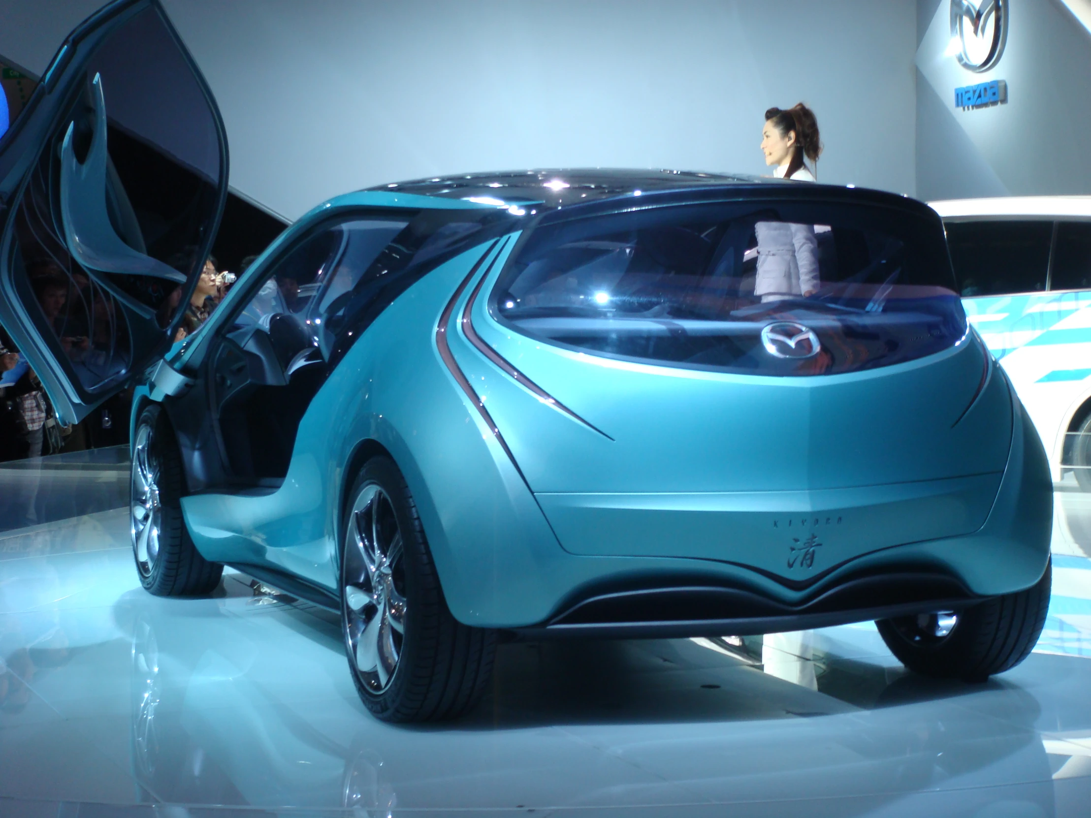 a small blue car is on display on a floor