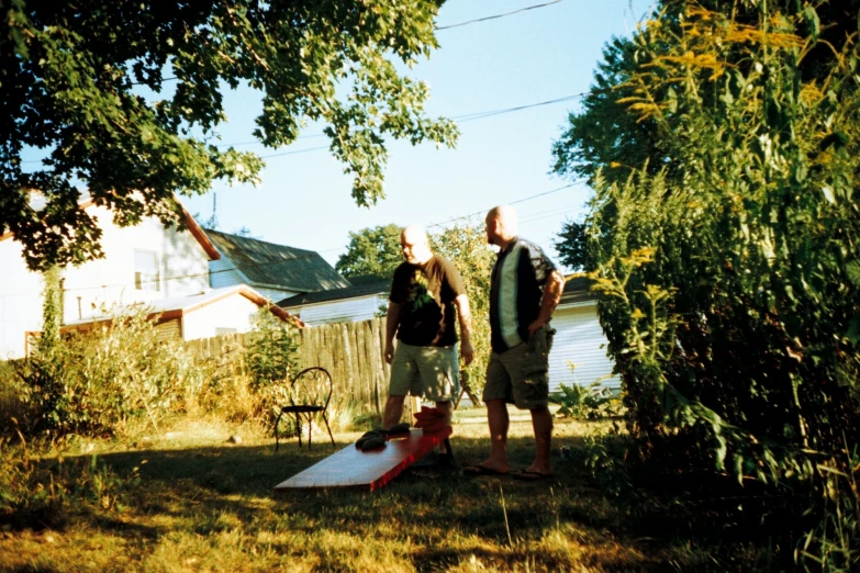 two people in a backyard with trees and houses