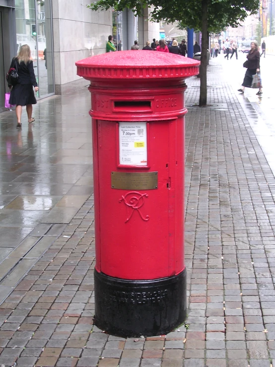 a red mailbox sitting on the side of a street