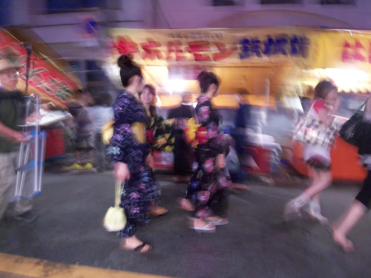 several people wearing colorful clothing walk down the street