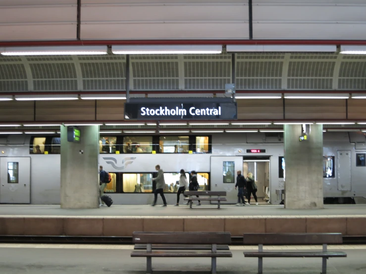 a train station with benches near a train platform