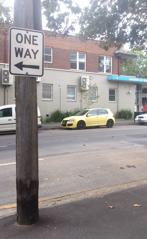 one way sign posted near a small street