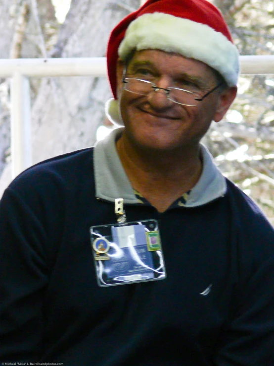 a man in a santa hat smiling and posing for a picture