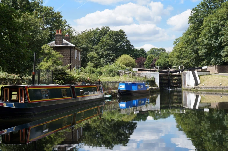 two small boats floating down a canal surrounded by trees