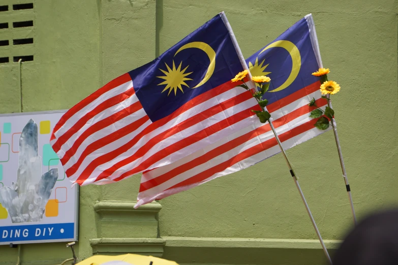 the two flags with malaysia and malaysian flags are placed next to each other