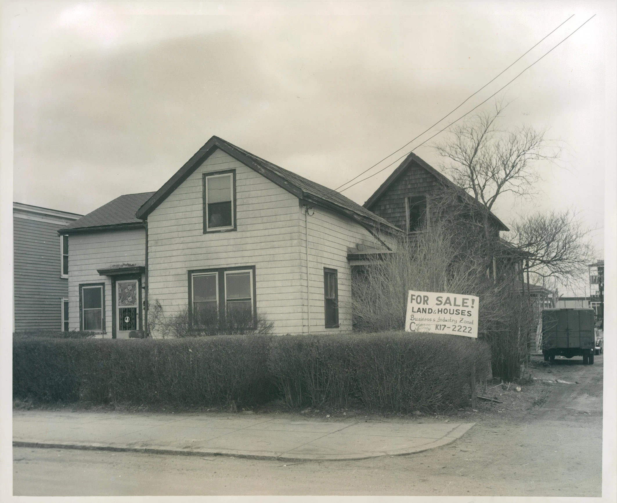 an old po shows the front of a small house with vines