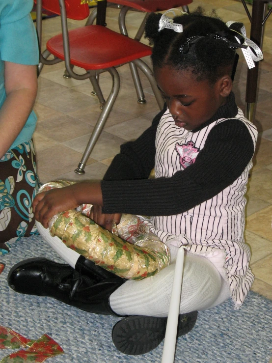 a  is sitting on the floor with a crochet bag