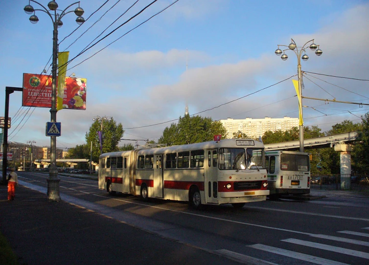 two public transit buses next to each other on the street