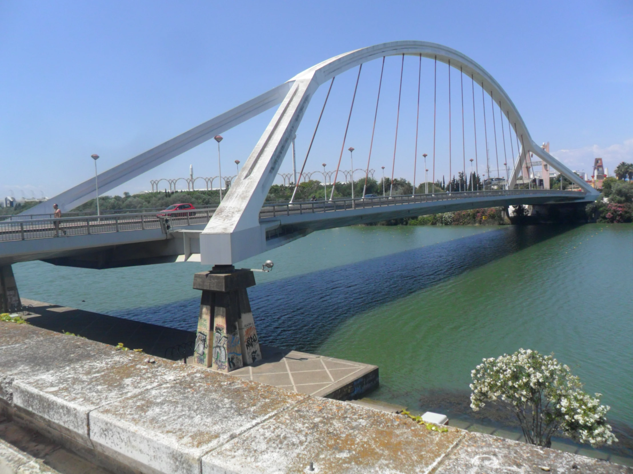 a bridge over water near a cement wall