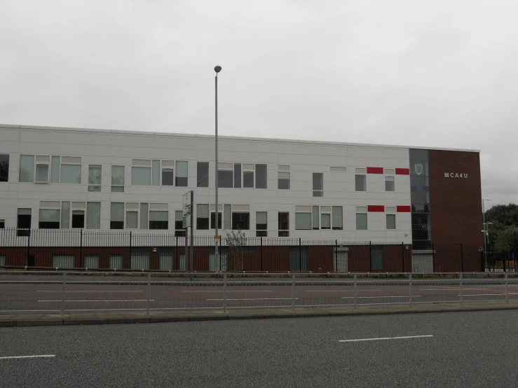 the large white building has a red and red stripe on it