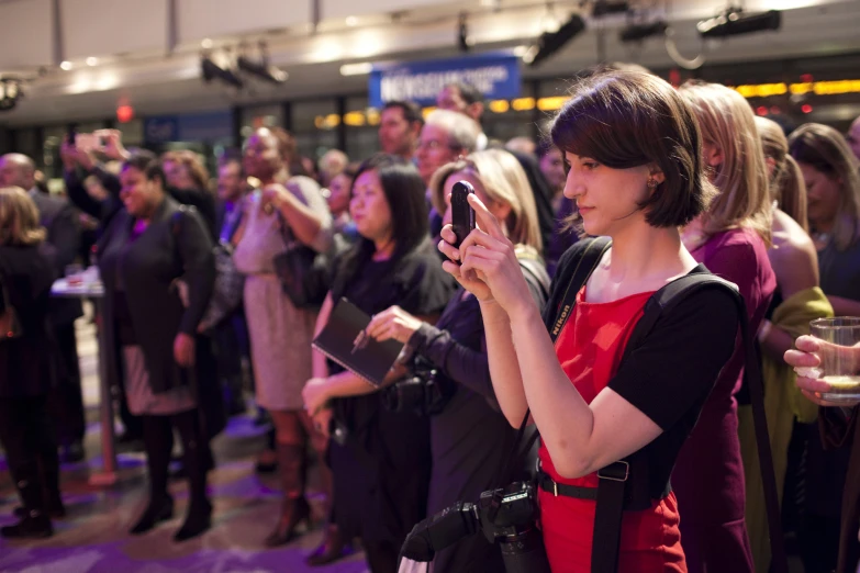 woman using cell phone at event in busy shopping area