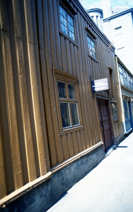 an older building is brown and white next to the road