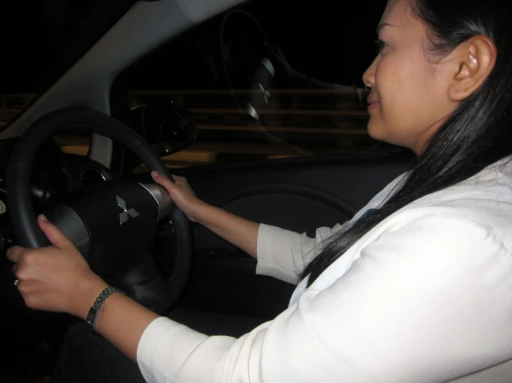 a woman is driving a car in the dark