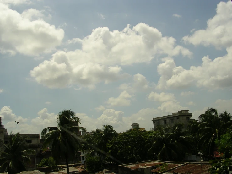 a cloudy sky above some very large buildings