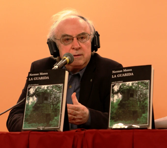 a man is singing into a microphone, with two pictures on the stand