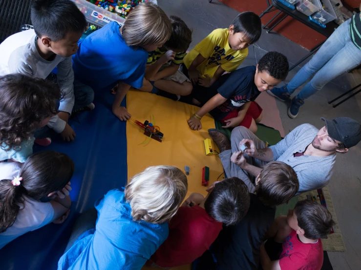 a group of people sitting around a yellow table