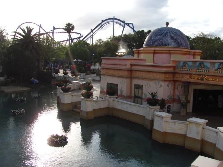 a building near a roller coaster and a pond