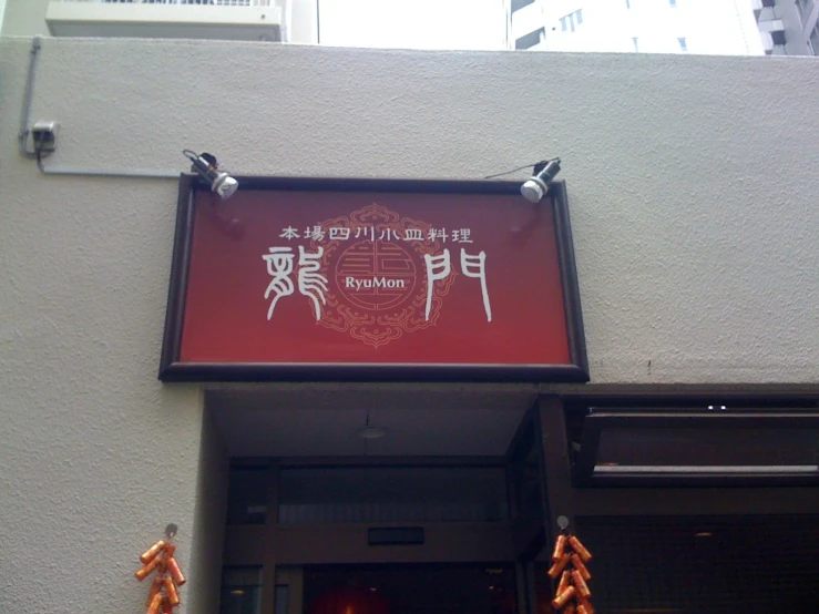 a chinese restaurant with red signs hanging on a building