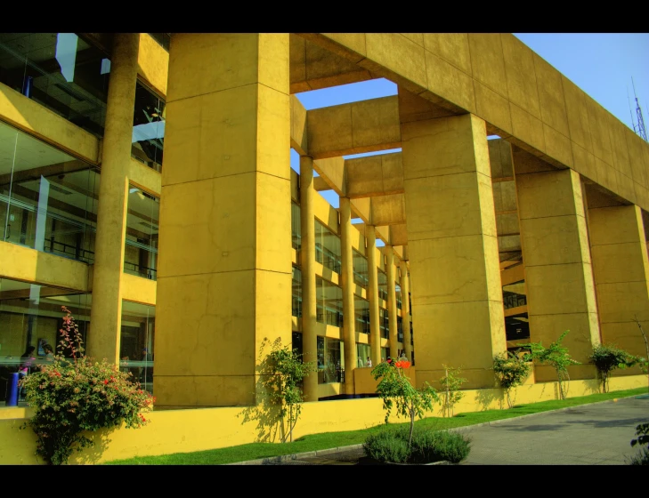 a large yellow building with planters of flowers in front