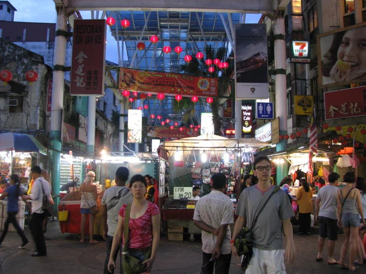 many people are walking around an open market