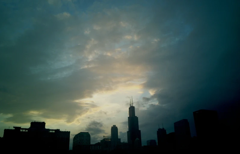 a city at night with a large cloud over it