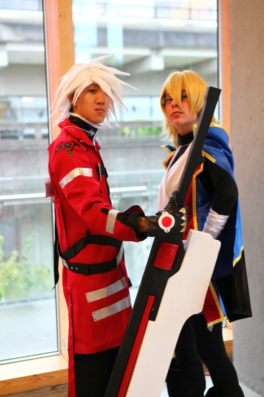 two people in costume posing next to a window