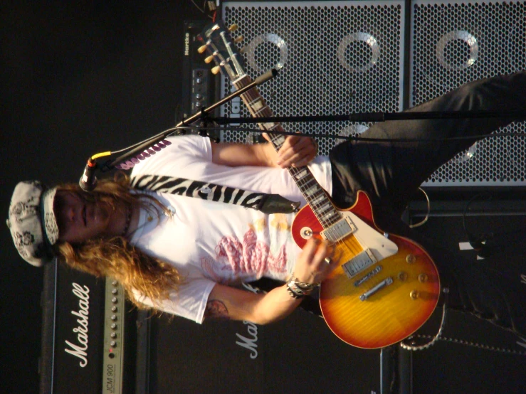 a man with long hair is holding his guitar