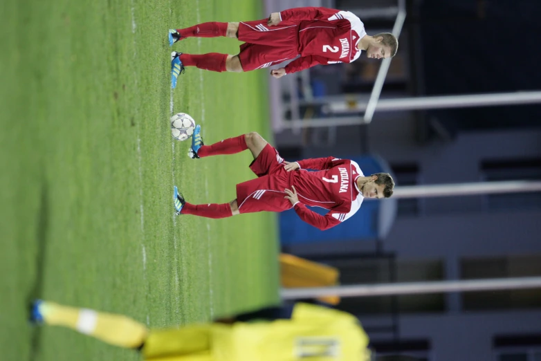 a couple of people playing soccer on a field