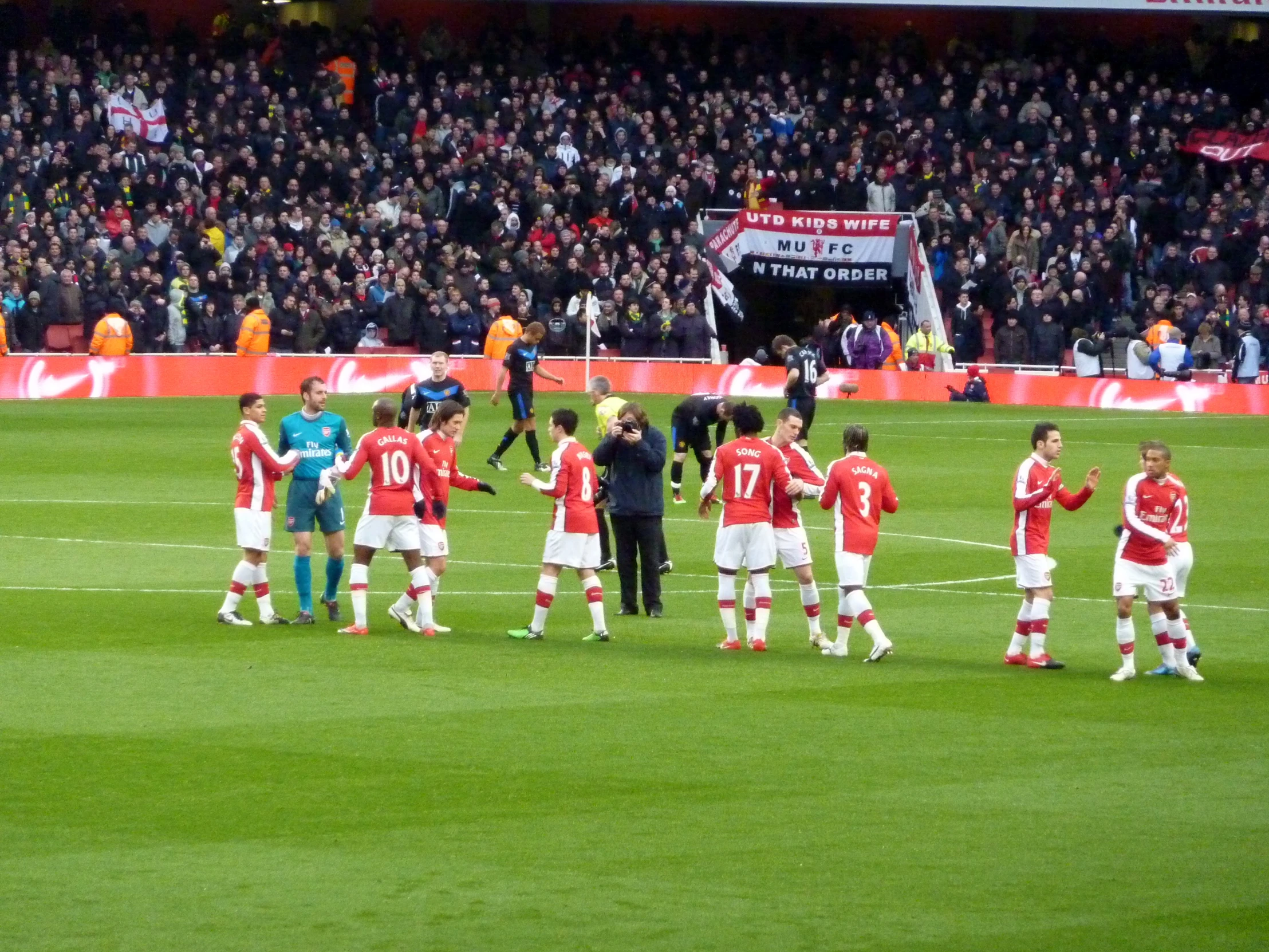 the players from both teams are standing together on the soccer field