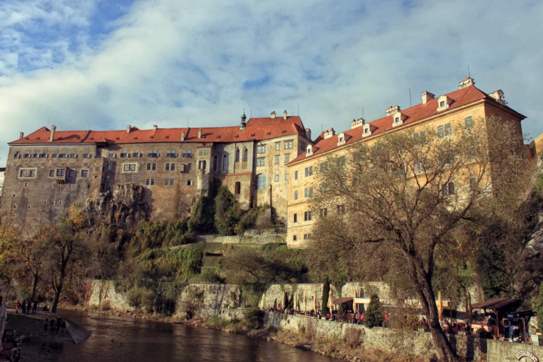 a castle sitting on top of a hillside near water