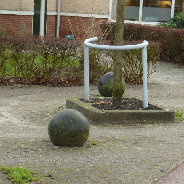 three sculptures are on the sidewalk near two trees