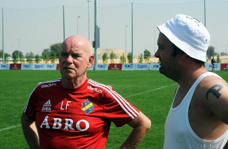 two men are standing on a soccer field