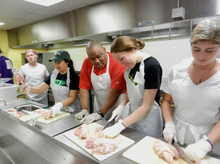 a group of people working on  up meat